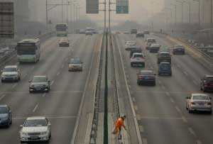 road_worker_picks_up_trash_in_smoggy_Beijing
